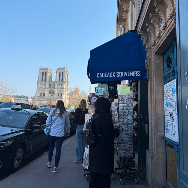 Picture of street with souvenir stores and Notre Dame on the left